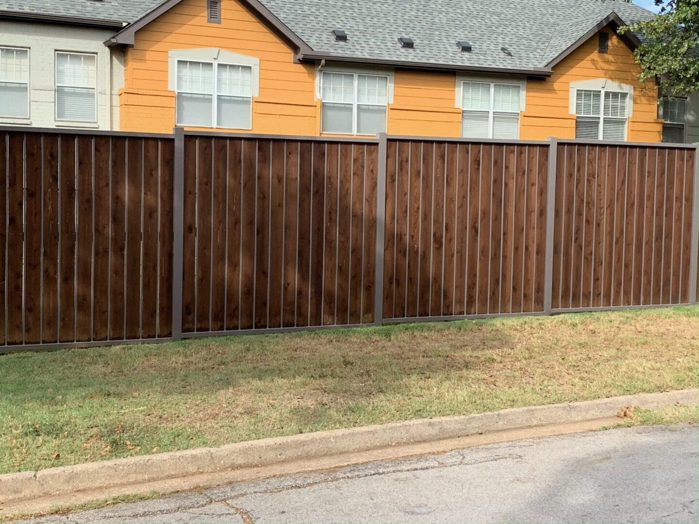 A brown fence with houses in the background